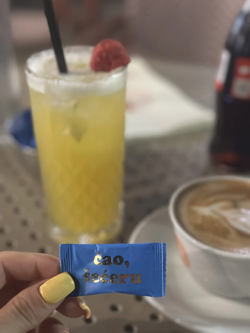 Žuti koktel sa malinom i poruka Ćao, šećeru na stolu u Kecu